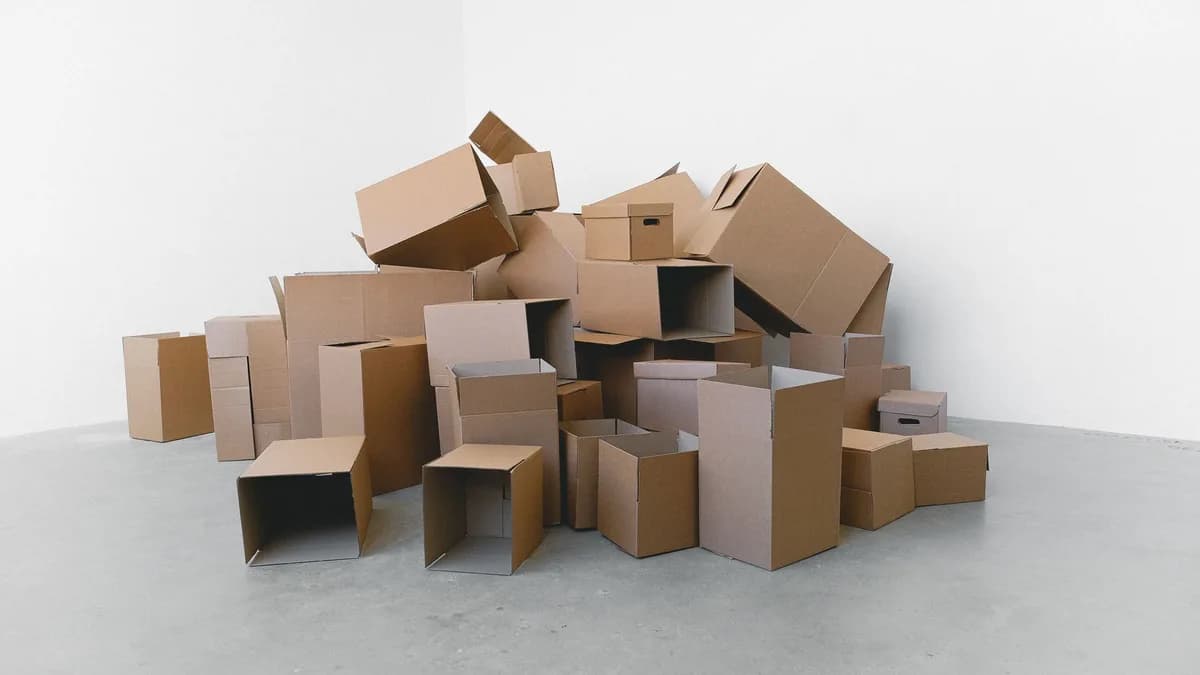 Plain stacked cardboard shipping boxes in a warehouse aisle. Decorative stock image.