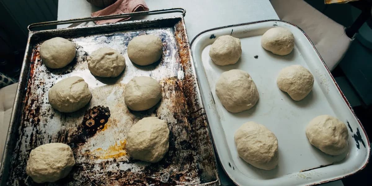Balls of raw dough resting on baking trays — decorative stock image