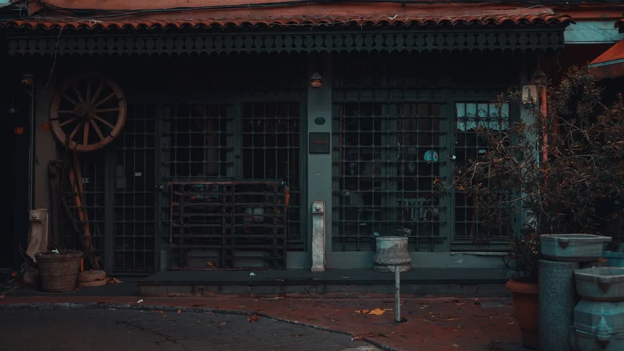 Moody vintage shop facade with iron grates and old wagon wheel.