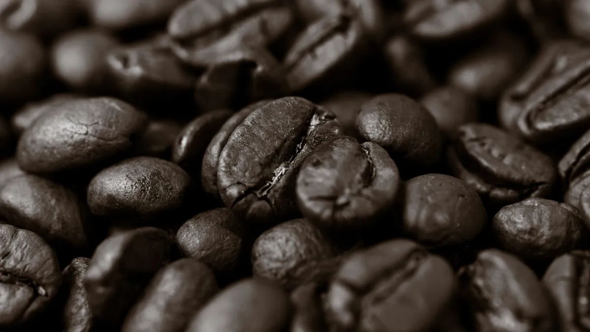 Detailed close-up of roasted coffee beans, highlighting texture and rich brown color.