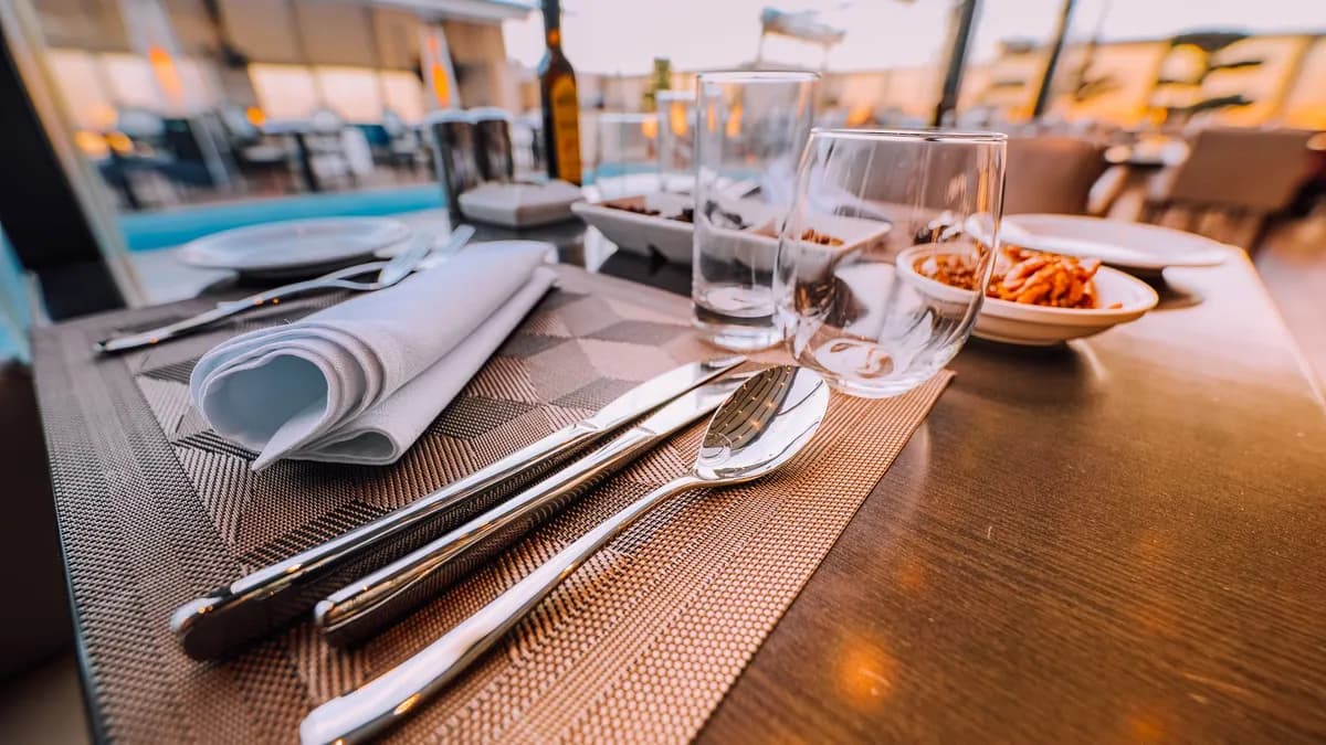 Close-up of an elegant table setting at a stylish outdoor restaurant with ambient lighting.