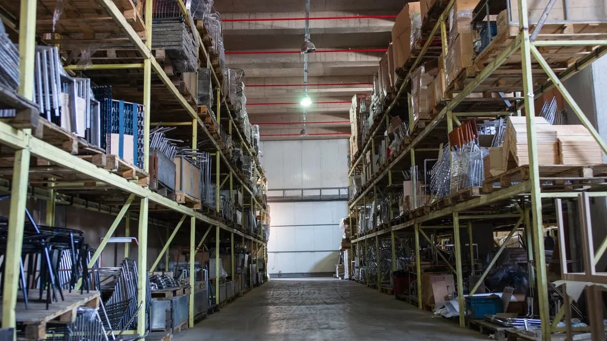 Wide aisle in a spacious warehouse filled with industrial metal shelving units.