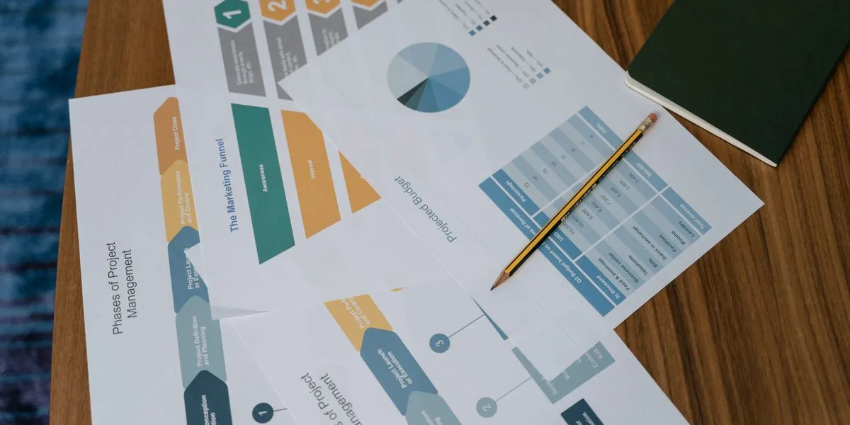 Printed marketing-funnel and analytics charts on a desk — decorative stock image